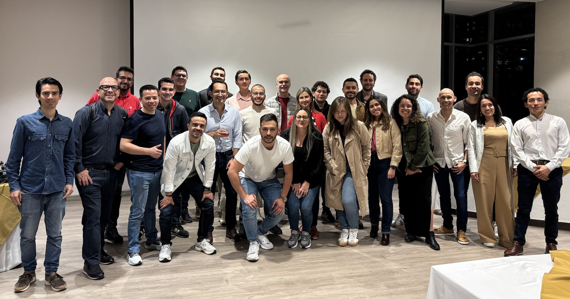Foto grupal de unas treinta personas en un salón.
